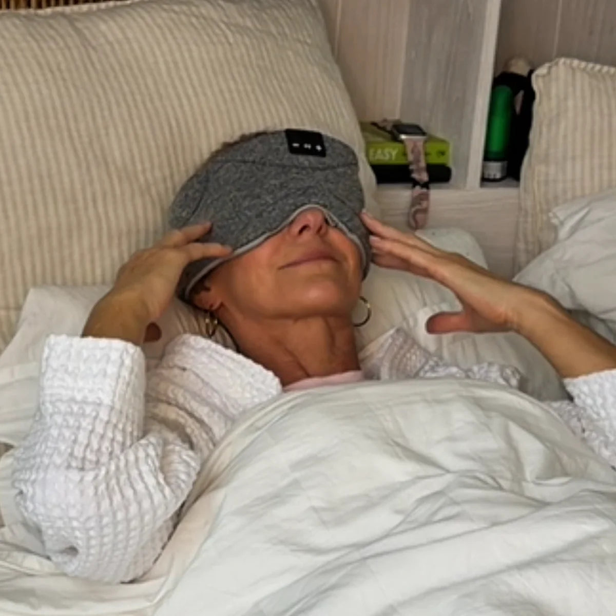 Somny Solutions customer relaxing in bed with the sound sleep mask